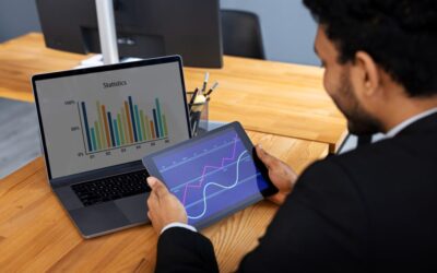 Un homme compare des statistiques sur un ordinateur portable et un graphique interactif sur une tablette, possiblement générés ou analysés avec Galileo AI