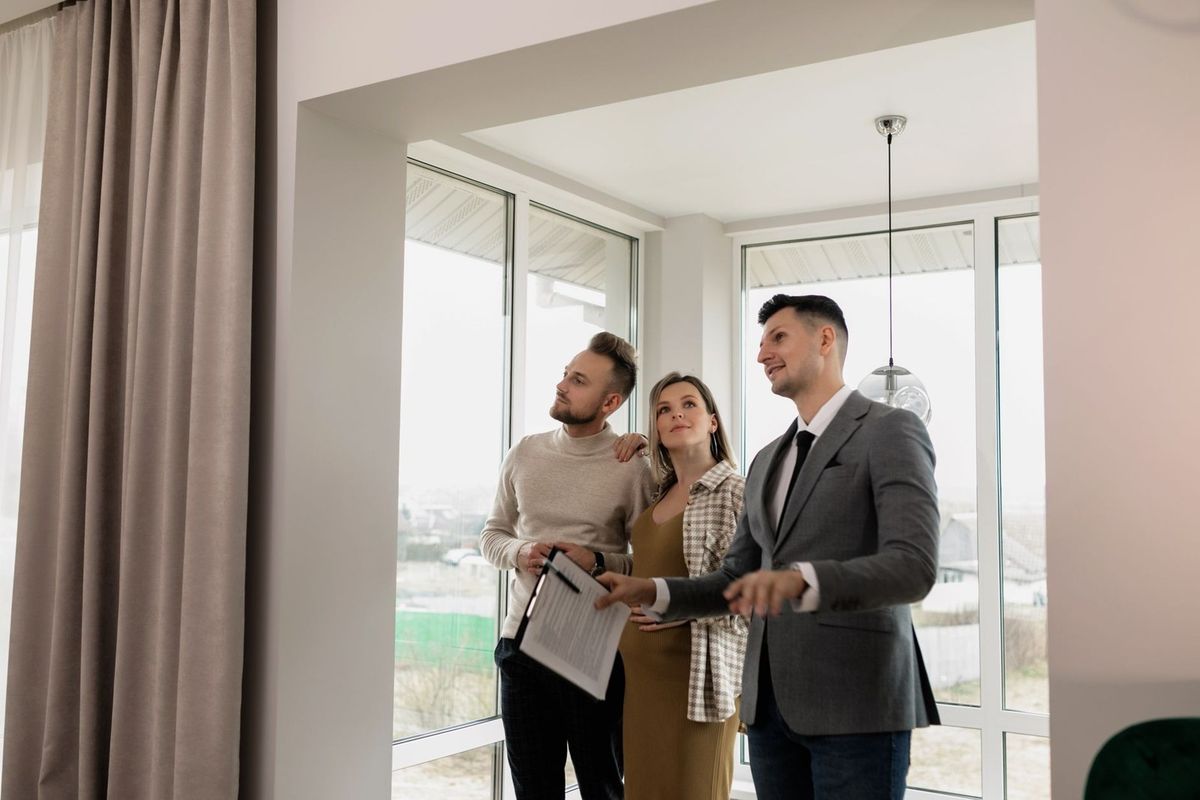 Groupe de trois personnes à l'intérieur d'une maison, un document en main