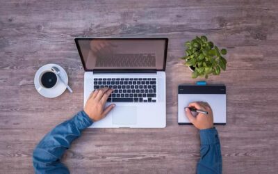 Une personne travaille sur ordinateur portable et utilise une tablette graphique
